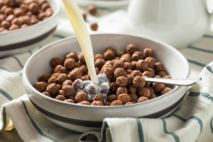 chocolate cereal puffs in a bowl with milk
